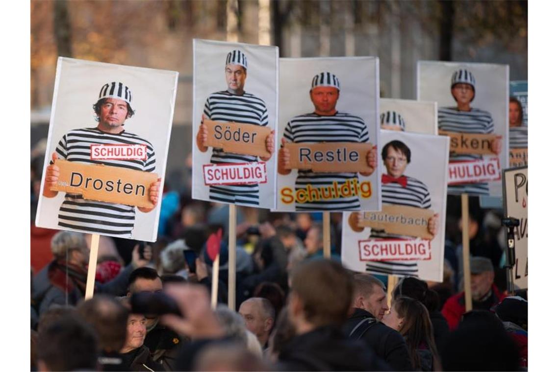 Sachsens Innenminister nach „Querdenken“-Demo unter Druck „Schuldig“: Schilder mit Foto-Montagen werden von Demonstranten in Leipzig getragen. Foto: Sebastian Kahnert/dpa-Zentralbild/dpa