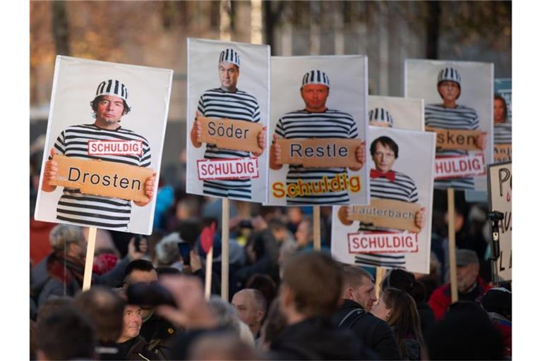 „Schuldig“: Schilder mit Foto-Montagen werden von Demonstranten in Leipzig getragen. Foto: Sebastian Kahnert/dpa-Zentralbild/dpa