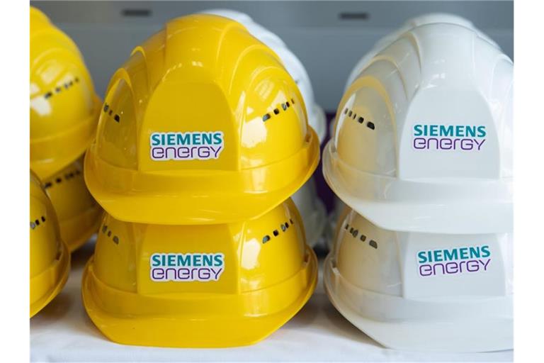 Schutzhelme mit der Aufschrift „Siemens Energy“ liegen in einer Halle auf einem Tisch. Foto: Sebastian Kahnert/dpa-Zentralbild/dpa/Symbolbild
