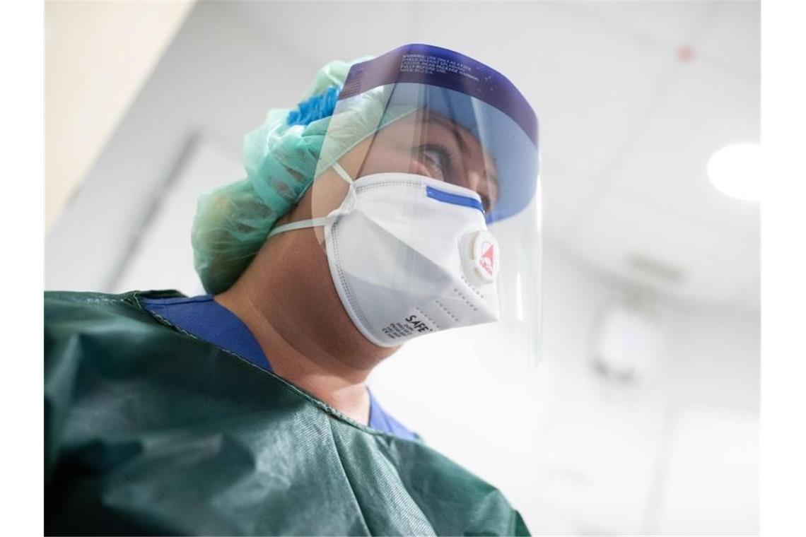 Coronavirus: Hamsterkäufe und abgesagte Veranstaltungen Schutzkleidung und Atemmaske: Die Mitarbeiterin einer Infektionsstation. Foto: Marcel Kusch/dpa