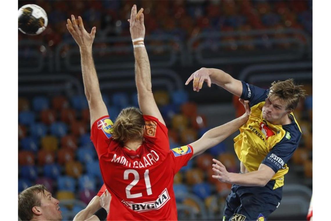 „Wirklich stolz“: Landin und Dänemark erneut Weltmeister Schwedens Jonathan Carlsbogard (r) kommt gegen den blockenden Dänen Henrik Möllgaard Jensen zum Wurf. Foto: Petr David Josek/AP/dpa