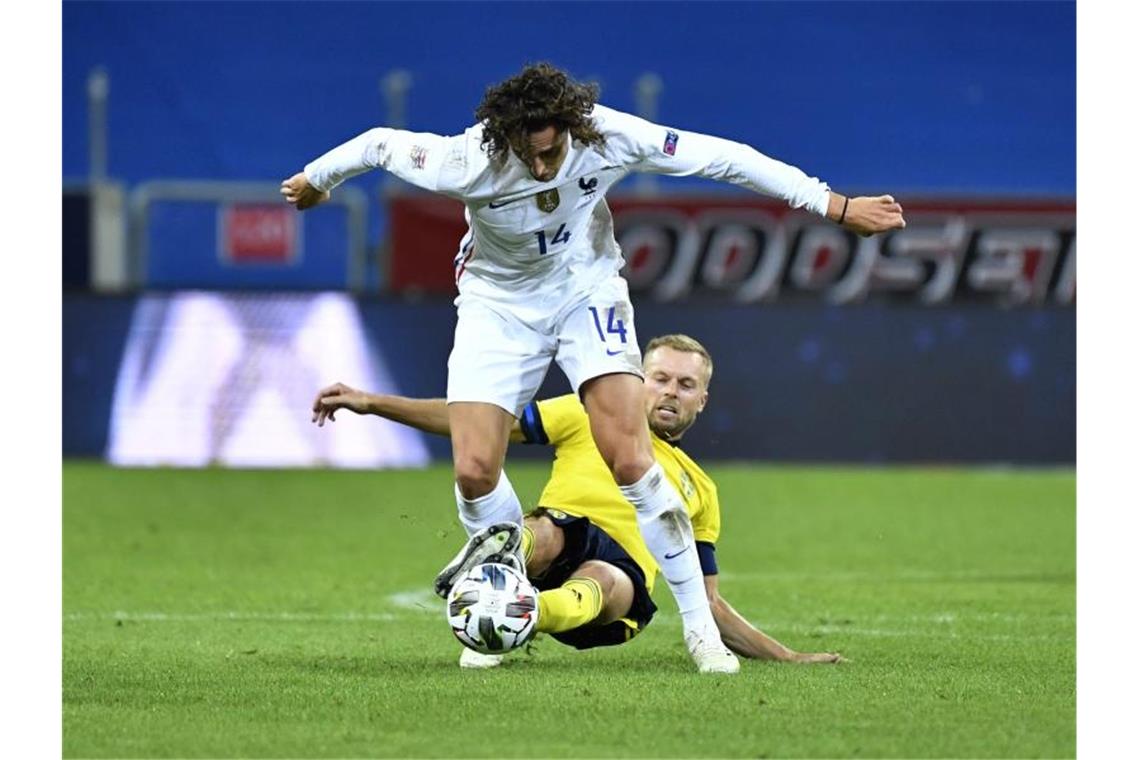 Schwedens Sebastian Larsson versucht alles um Frankreichs Adrien Rabiot (oben) vom Ball zu trennen. Foto: Jessica Gow/TT NEWS AGENCY/dpa