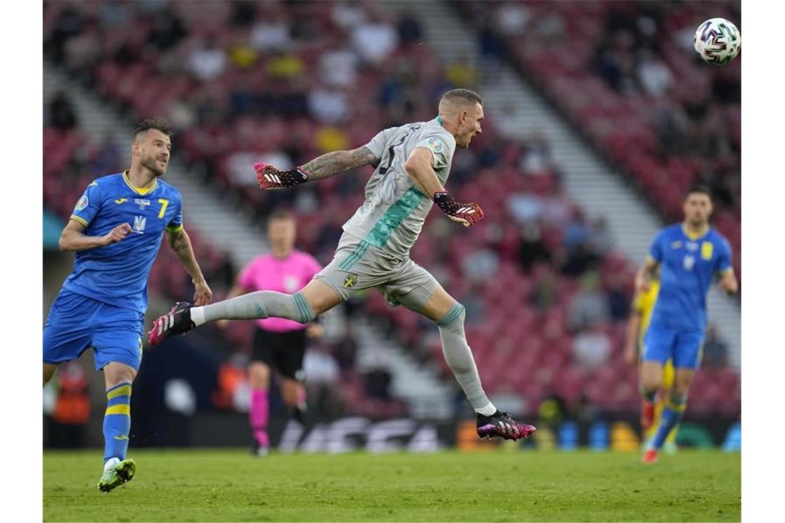 Schwedens Torwart Robin Olsen (M) klärt den Ball per Kopf vor dem Ukrainer Andrej Jarmolenko. Foto: Petr David Josek/Pool AP/dpa