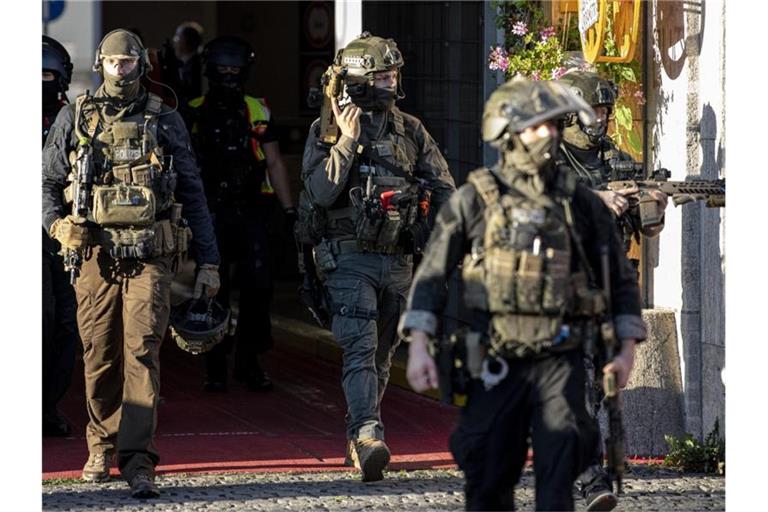 Schwer bewaffnete Polizeibeamte verlassen das Kaufhaus am Hermannplatz. Foto: Fabian Sommer/dpa
