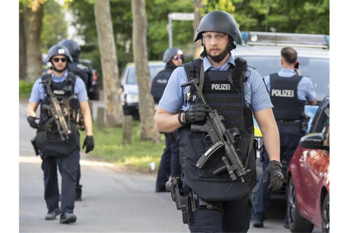 Schwer bewaffnete Polizisten sichern nach einer Schießerei ein Wohngebiet in Darmstadt-Kranichstein. Foto: Boris Roessler/dpa