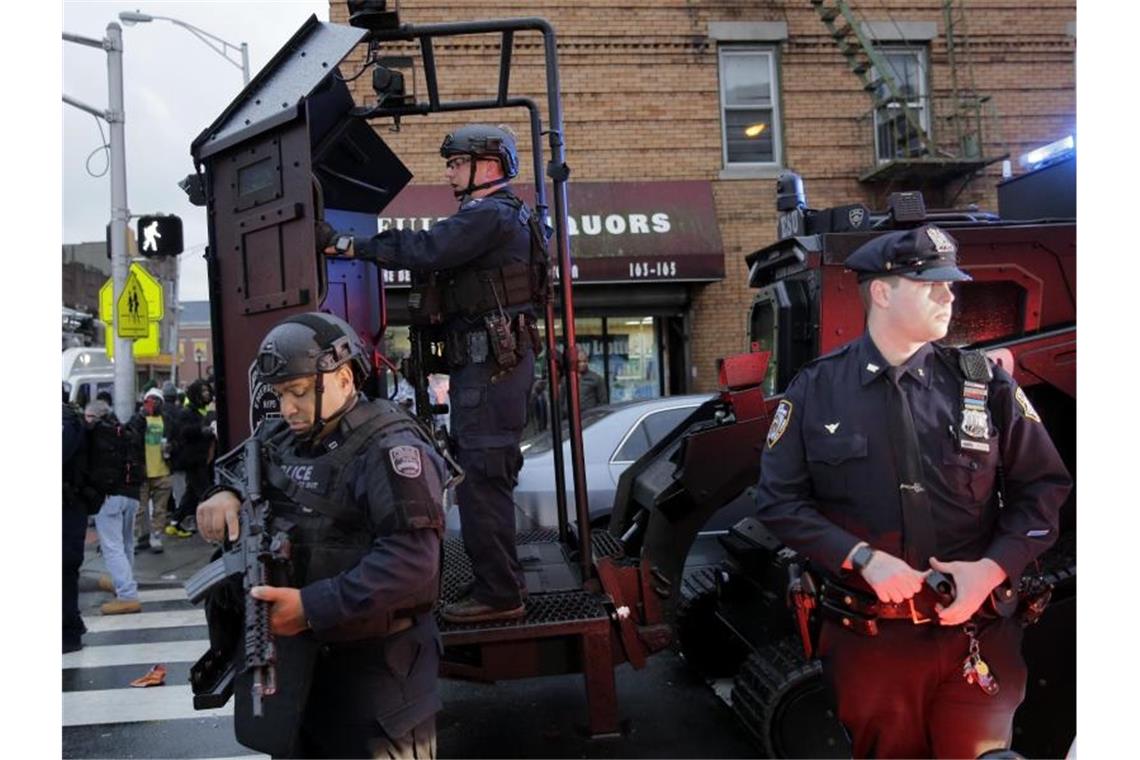 Schwer bewaffnete Polizisten sichern während der stundenlang andauernden Schießerei einen Straßenzug in Jersey City. Foto: Seth Wenig/AP/dpa