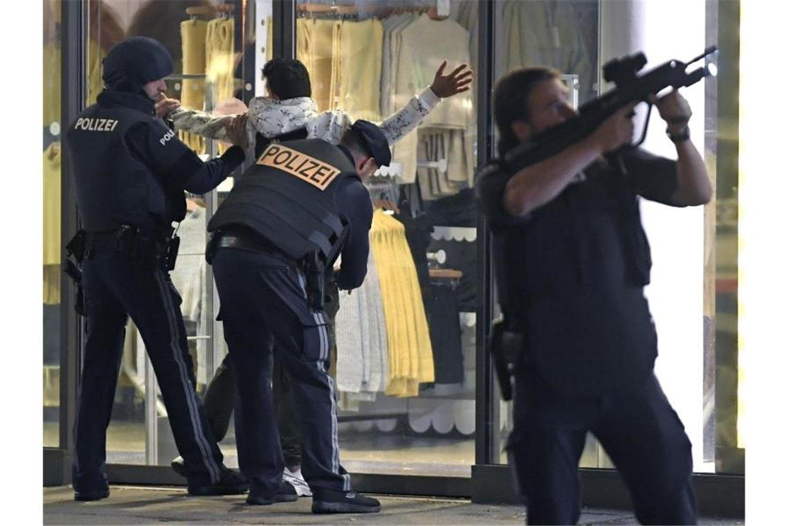 Schwerbewaffnete Polizisten kontrollieren in der Wiener Innenstadt eine Person. Nach einem Anschlag dort, gab es auch Terrorbotschaften im Netz. Foto: Roland Schlager/APA/dpa