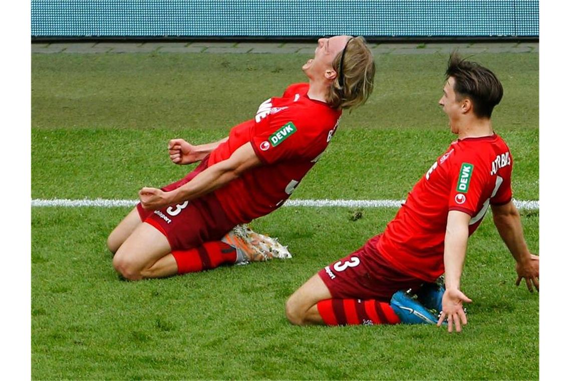 Bremer Abstieg, Lewandowskis Rekord, Kruses Party Sebastiaan Bornauw (l) und Noah Katterbach jubeln über den Siegtreffer, mit dem sich der 1. FC Köln auf den Relegationsplatz geschoben hat. Foto: Thilo Schmuelgen/Reuters-Pool/dpa