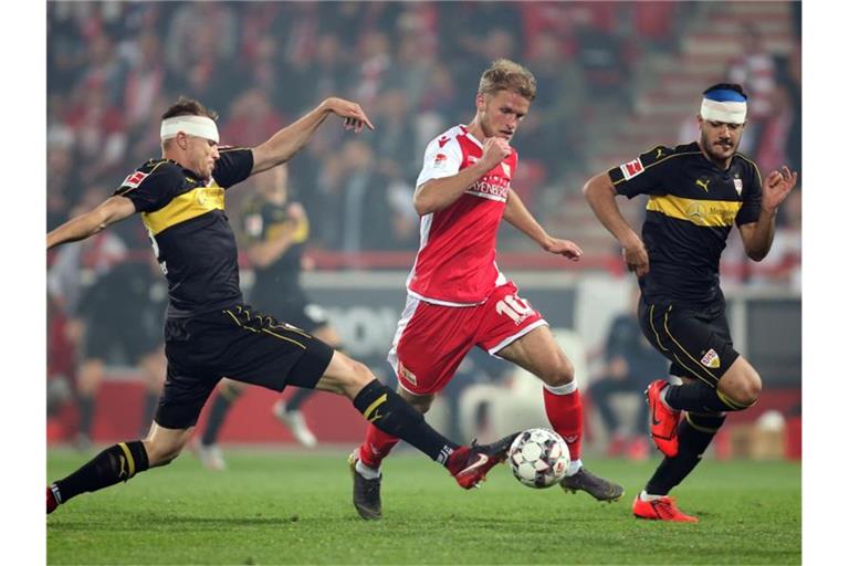 Sebastian Andersson (M) von Union und Holger Badstuber (l) und Ozan Kabak (r) von Stuttgart Stuttgart kämpfen um den Ball. Foto: Andreas Gora