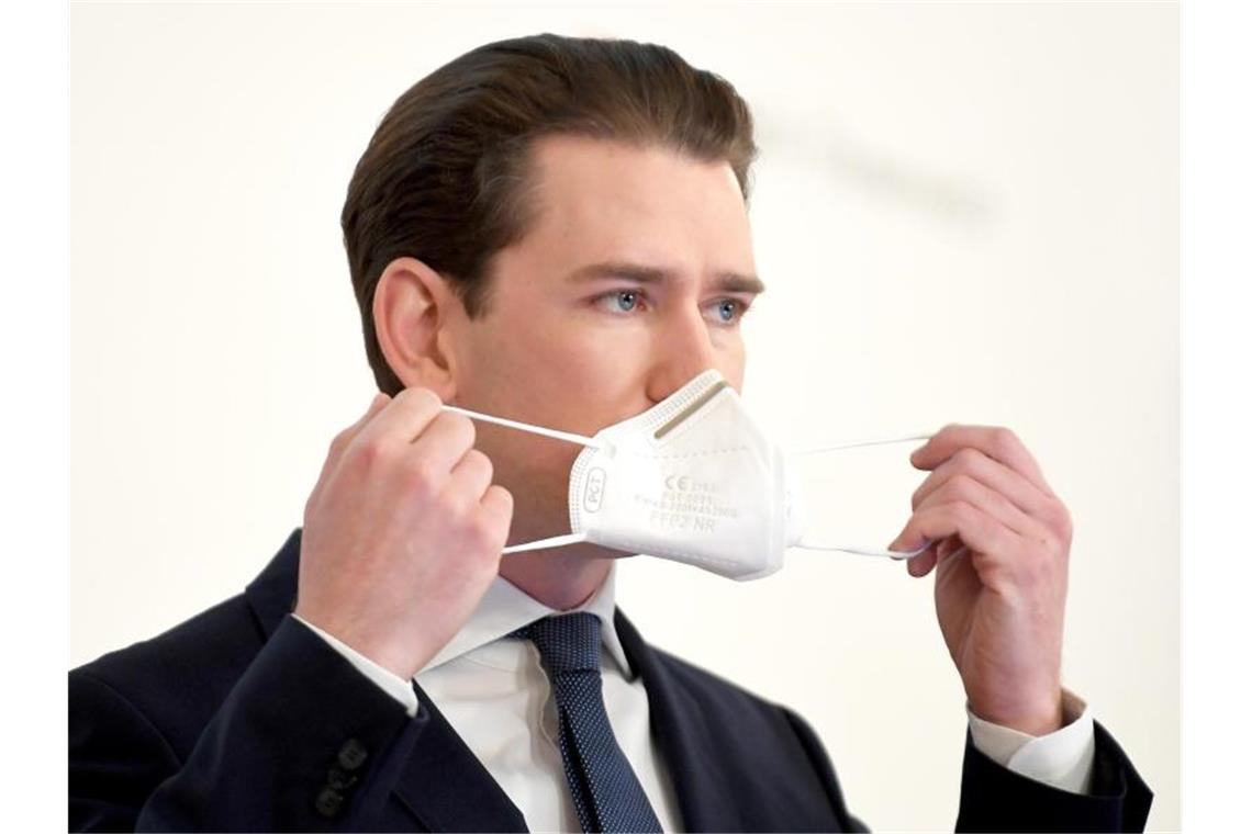 Sebastian Kurz (ÖVP), Bundeskanzler von Österreich, setzt bei einer Pressekonferenz seine Mund-Nasen-Bedeckung auf. (Archivbild). Foto: Roland Schlager/APA/dpa
