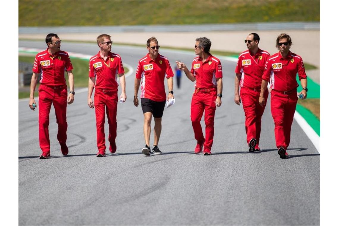 Sebastian Vettel (M) geht mit seinem Team die Rennstrecke in Spielberg ab. Foto: Georg Hochmuth/APA/APA