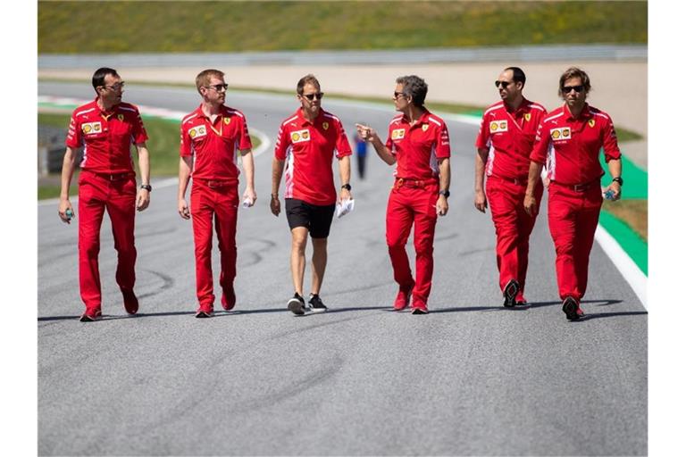 Sebastian Vettel (M) geht mit seinem Team die Rennstrecke in Spielberg ab. Foto: Georg Hochmuth/APA/APA