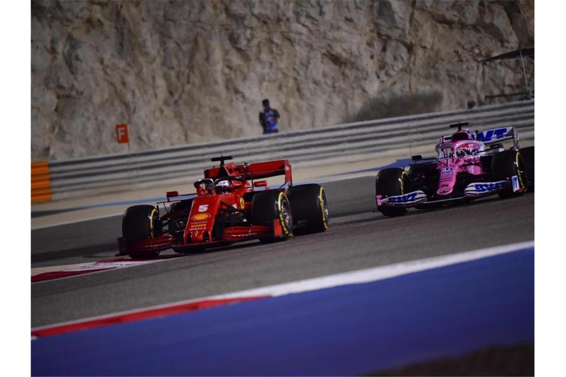 Sebastian Vettel vom Team Scuderia Ferrari steuert sein Auto auf der Rennstrecke vor dem späteren Sieger Sergio Perez vom Team Racing-Point. Foto: Giuseppe Cacace/Pool AFP/AP/dpa