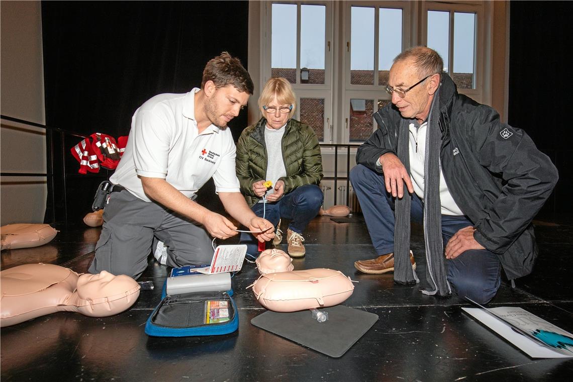 Sebastian Wörner vom DRK erklärt Karin und Michael Weik, wie ein Defibrillator und die Herzdruckmassage funktionieren. Foto: A. Becher