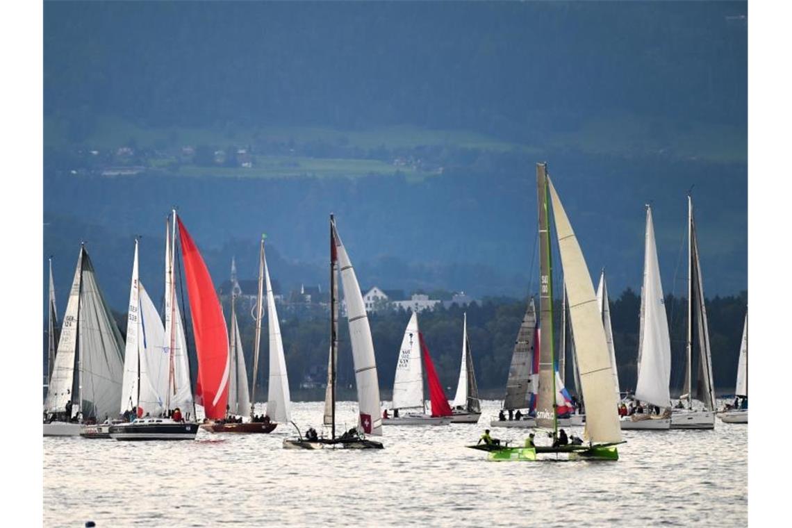 Größte Bodensee-Regatta dümpelt bei Flaute vor sich hin Segelboote gehen bei der größten Regatta am Bodensee, der „RUND UM“, an den Start. Foto: Felix Kästle/dpa