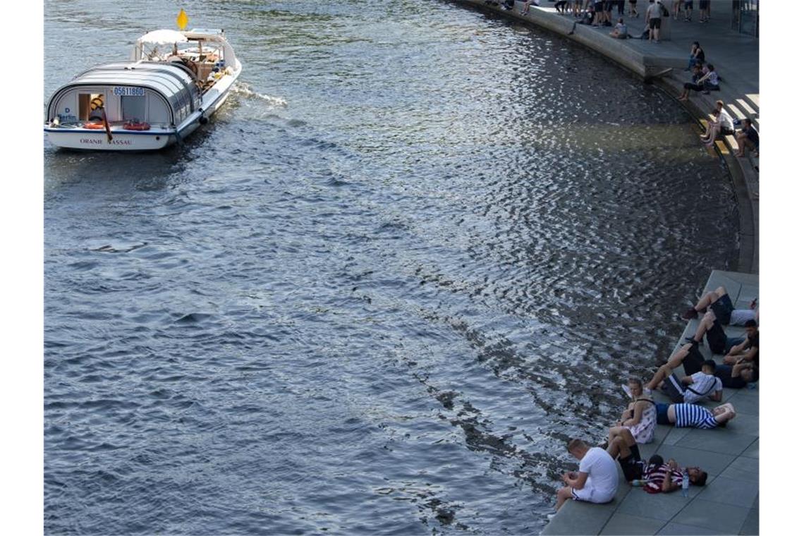 Gewitter ziehen nach Osten - Waldbrand breitet sich aus Sehr heiß war es in den vergangenen Tagen in Berlin: Menschen an der Spree im Schatten des Paul-Löbe-Hauses. Foto: Paul Zinken