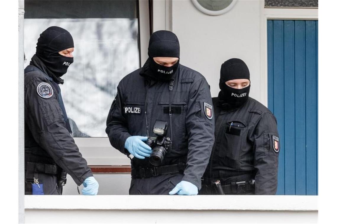 SEK-Beamte stehen während einer Razzia vor einer Wohnung in Bad Segeberg. Foto: Markus Scholz/dpa