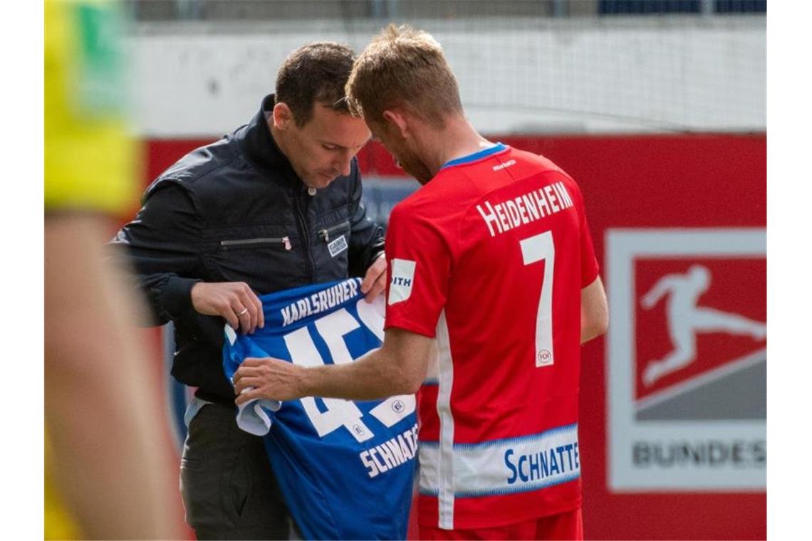 Selbst von KSC-Coach Christian Eichner erhielt Heidenheim-Legende Marc Schnatterer (r) zum Abschied ein Geschenk. Foto: Stefan Puchner/dpa