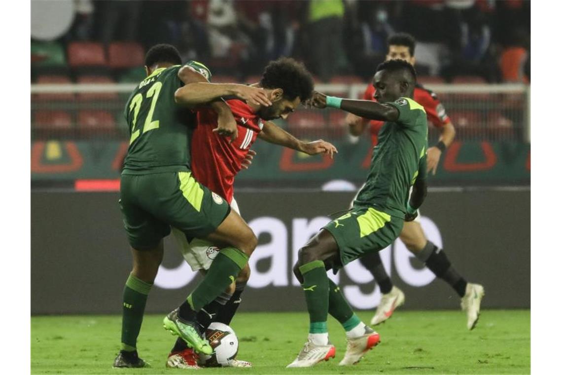Senegal gewinnt Endspiel gegen Ägypten im Elfmeterschießen Senegals Abdou Diallo (l) und Idrissa Gueye (r) versuchen Ägyptens Mohamed Salah den Ball abzunehmen. Foto: Ayman Aref/dpa