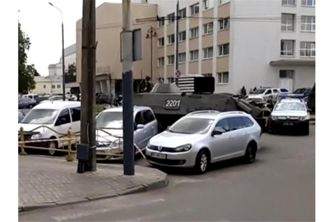 Sicherheitskräfte am Ort des Geschehens haben mit einem gepanzerten Sicherheitsfahrzeug eine Straße abgesperrt. Foto: Uncredited/AP/dpa