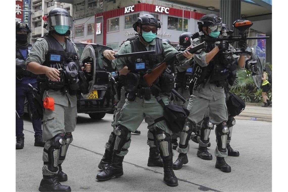 Proteste in Hongkong - „Totengeläut für Autonomie“ Sicherheitskräfte feuern Tränengas ab, während Hunderte Demonstranten bei einem pro-demokratischen Protest gegen die nationale Sicherheitsgesetzgebung Pekings durch Hongkongs Stadtzentrum laufen. Foto: Vincent Yu/AP/dpa