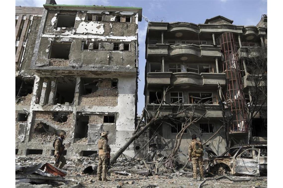 Nun 24 Tote nach Anschlag in Kabul Sicherheitskräfte inspizieren durch den Anschlag zerstörten Gebäude. Foto: Rahmat Gul/AP