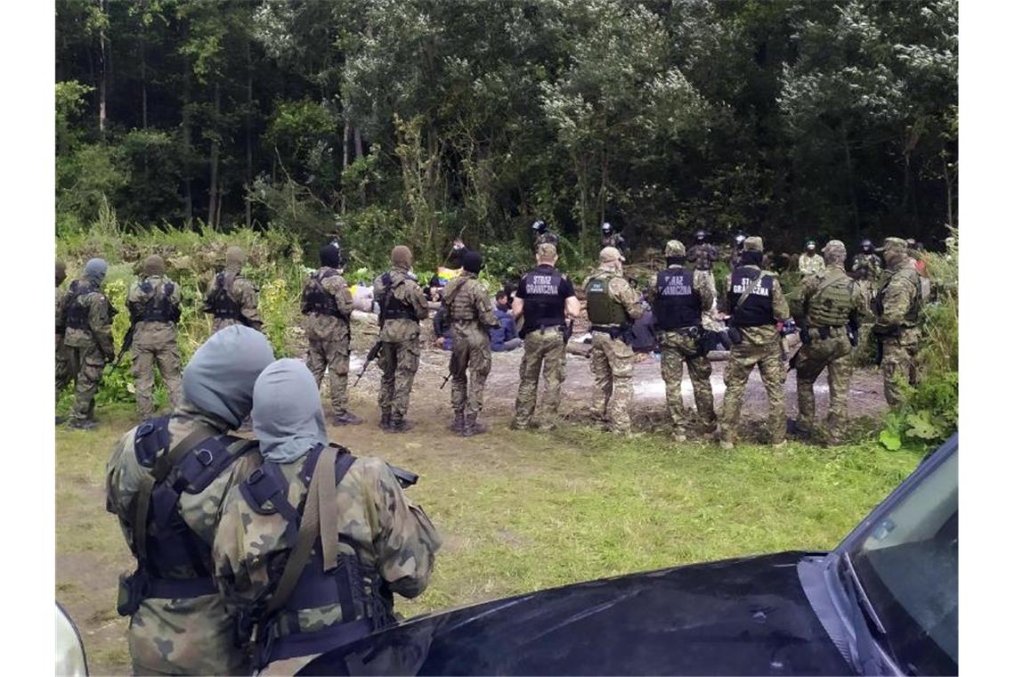 Polen plant Bau von „solider Barriere“ an Grenze zu Belarus Sicherheitskräfte kreisen Migranten ein, die über Belarus nach Polen gereist sind. Foto: Mateusz Wodziński/AP/dpa