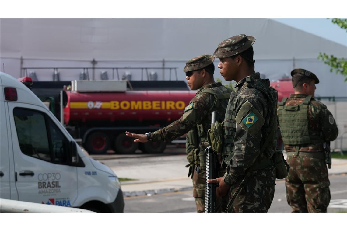 Sicherheitskräfte leiten Fahrzeuge nach einem Brand auf dem Gelände der Weltklimakonferenz.