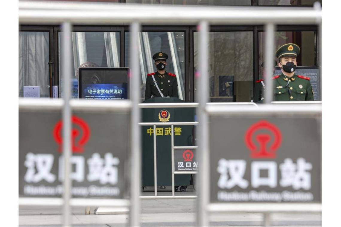 Chinesische Städte wegen Virus abgeriegelt Sicherheitskräfte stehen mit Mundschutz vor dem geschlossenen Bahnhof Hankou in Wuhan. Foto: --/CHINATOPIX/AP/dpa