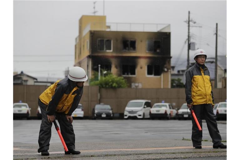 Sicherheitskräfte stehen nach dem Brandanschlag in der Nähe des Animationsstudios in Kyoto. Foto: Jae C. Hong/AP