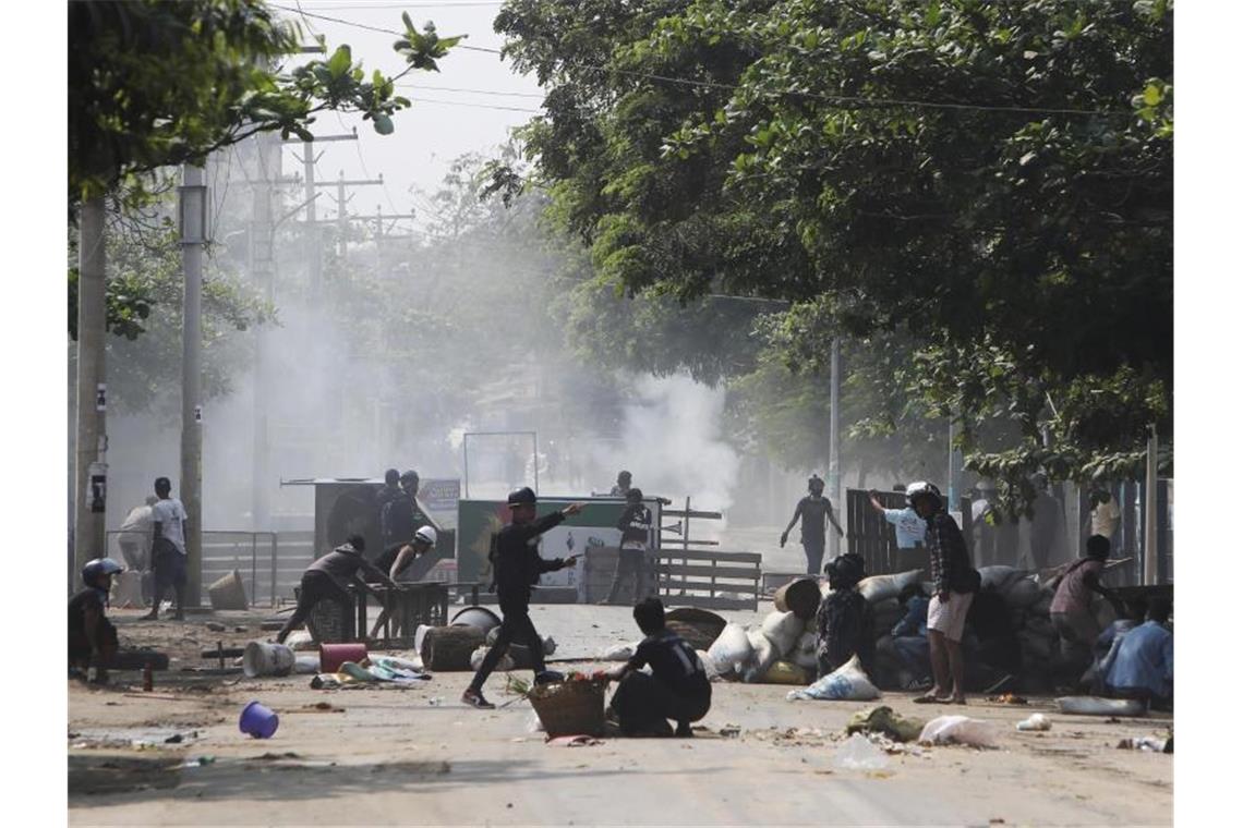 Sicherheitskräfte versuchen in Mandalay, Demonstranten von Barrikaden zu vertreiben. Foto: ---/AP/dpa