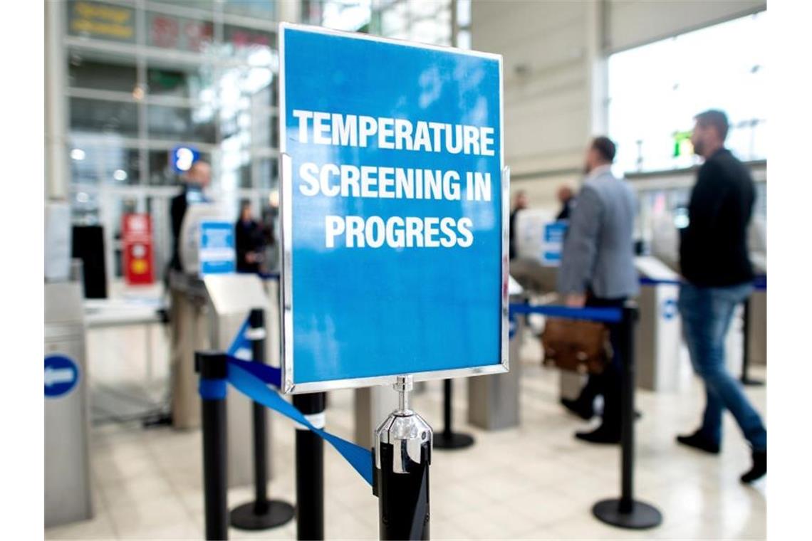 Sicherheitsmaßnahme auf der Reifenmesse in Hannover. Ein Schild weist am Eingang auf eine Einrichtung zur Messung der Körpertemperatur hin. Foto: Hauke-Christian Dittrich/dpa