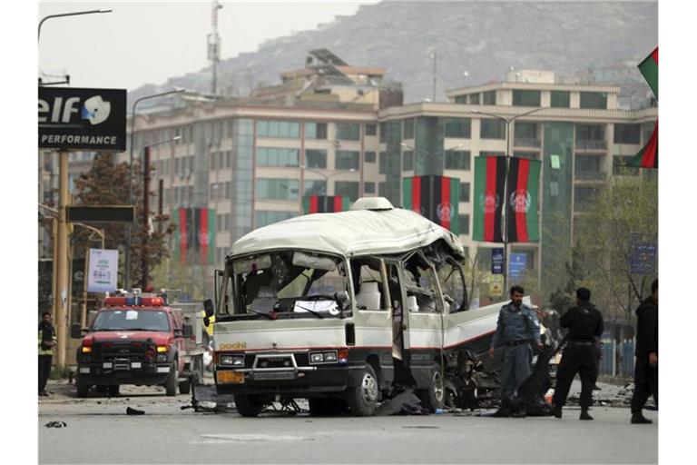 Sicherheitspersonal inspiziert den Ort eines Bombenanschlags. Eine Bombe, die auf einen Kleinbus in der afghanischen Hauptstadt Kabul abzielte, explodierte und verwundete nach Angaben der Polizei mindestens 15 Zivilisten. Foto: Rahmat Gul/AP/dpa