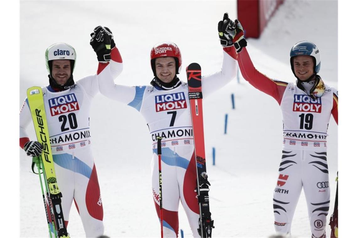 Sieger Loic Meillard (M) aus der Schweiz, der Dritte Alexander Schmid (r) und Thomas Tumler (l) aus der Schweiz. Foto: Gabriele Facciotti/AP/dpa