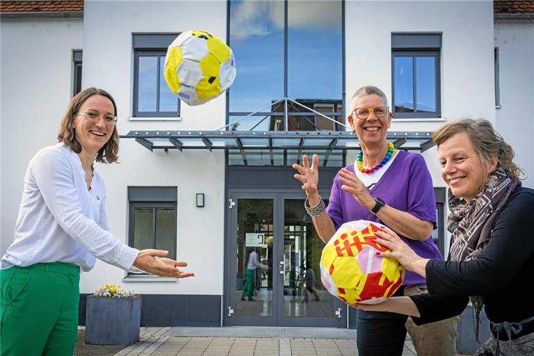 Silke Müller-Zimmermann (Mitte) und Claudia Fischer (rechts) vom Verein Weissach Klimaschutz konkret spielen Bürgermeisterin Patrizia Rall vor dem Allmersbacher Rathaus symbolisch die Bälle zu. Die Verwaltung soll sich jetzt in das Projekt einbringen. Foto: Alexander Becher