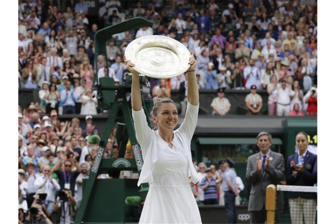Halep „wie von Sinnen“ - Williams verpasst Rekord Simona Halep durfte erstmals die Wimbledon-Trophäe in die Höhe halten. Foto: Kirsty Wigglesworth/AP