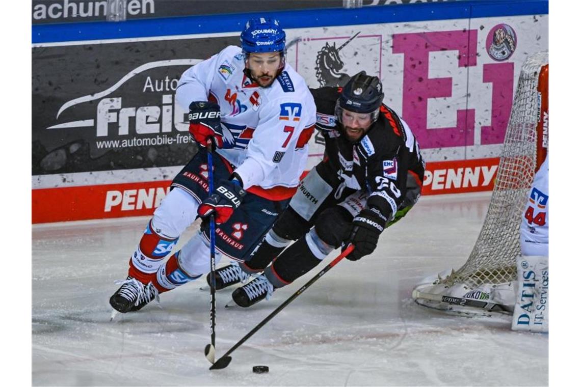 Sinan Akdag von Mannheim (l) und Andreas Eder von Straubing kämpfen um den Puck. Foto: Armin Weigel/dpa