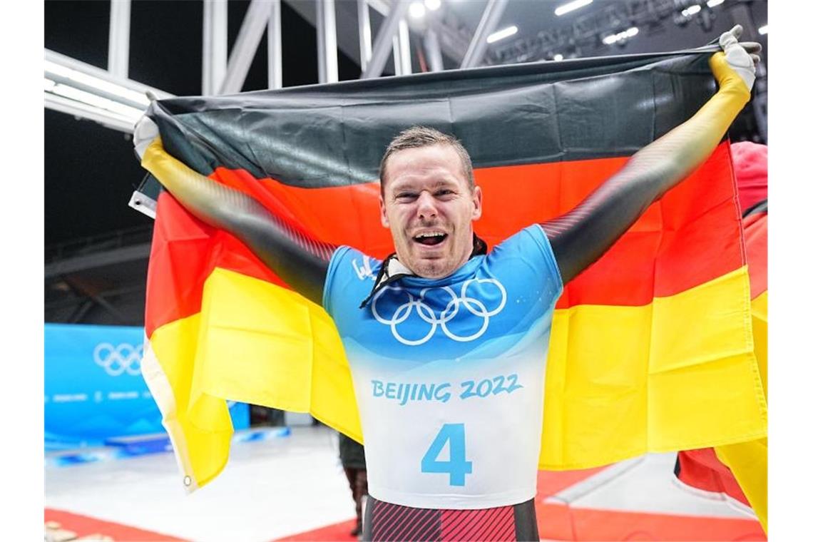 Olympiasieger Grotheer: „In meine eigene Welt fliehen“ Skeletonpilot Christopher Grotheer jubelt über den Olympiasieg. Foto: Michael Kappeler/dpa