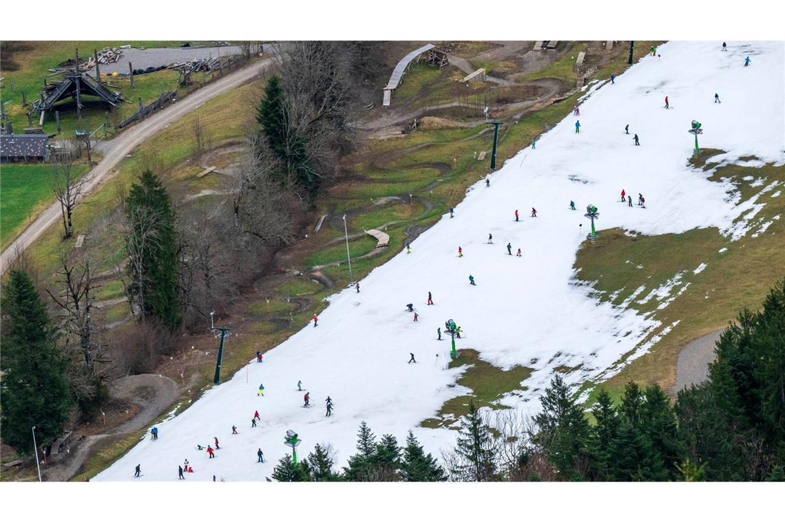 Skifahrer nutzen die schmale, künstlich beschneite Fläche im Talbereich des Skigebiets Brauneck für ihr Wintervergnügen.