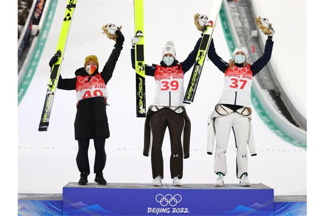 Überwältigte Zweite: Frohnatur Althaus und ihre Serie Skispringerin Katharina Althaus (l) freut sich bei der Siegerehrung über ihre Silbermedaile. Foto: Daniel Karmann/dpa