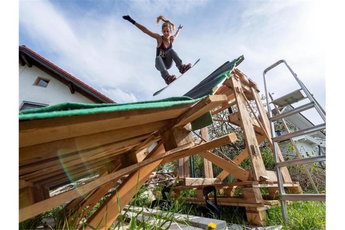 Do-it-yourself-Rampen im Garten: Wintersportler kreativ Snowboarderin Silvia Mittermüller trainiert auf ihrer selbstgebauten Mini-Schanze. Foto: Peter Kneffel/dpa