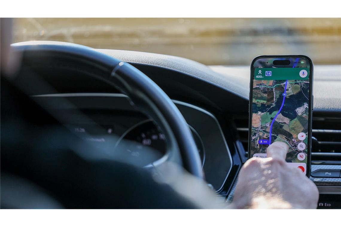 So ist es derzeit erlaubt: Das Handy steckt in der Halterung und wird nur kurz vom Fahrer beachtet. (Symbolbild)