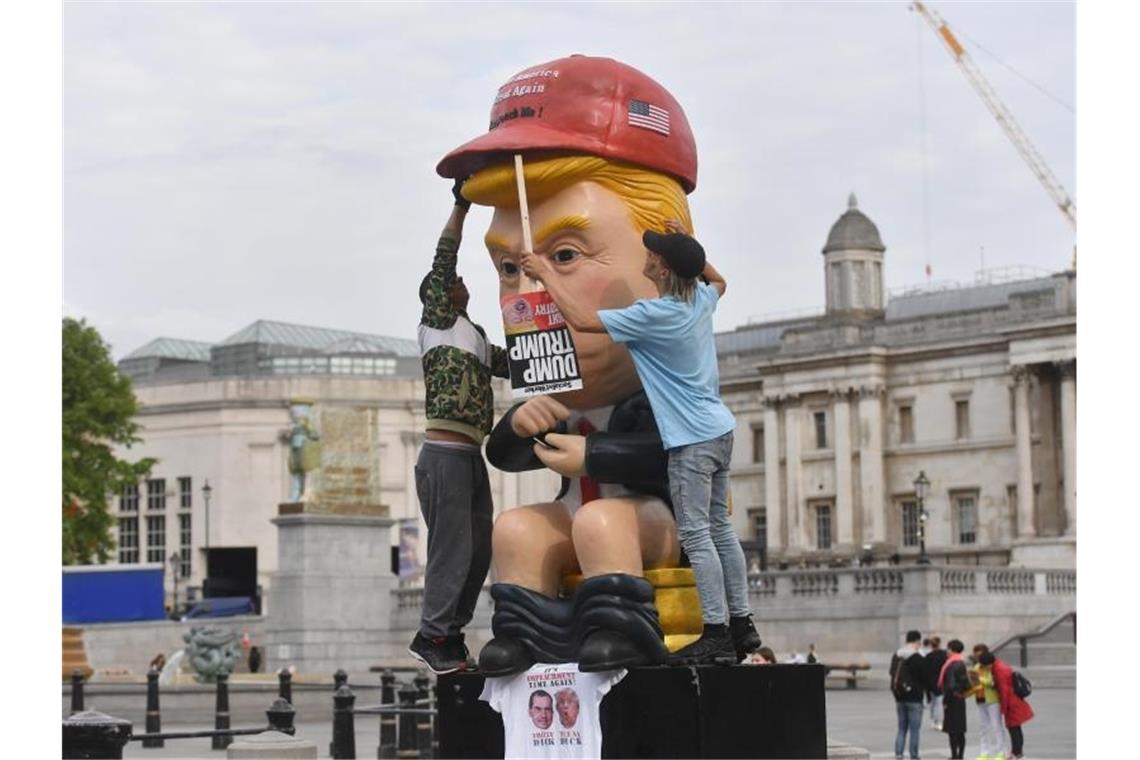 So sehen ihn manche Briten: Ein knapp 5 Meter großer sprechender Roboter, in der Anmutung von US-Präsident Trump sitzt am Trafalgar Square auf einer Goldtoilette. Foto: Jacob King/PA Wire