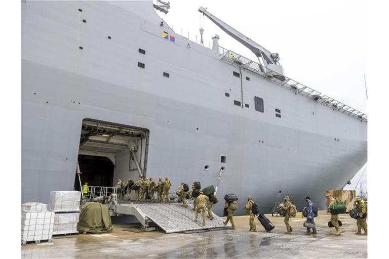 Soldaten betreten im Hafen von Brisbane die HMAS Adelaide bevor sie nach Tonga abreisen. Foto: Robert Whitmore/ADF/AP/dpa