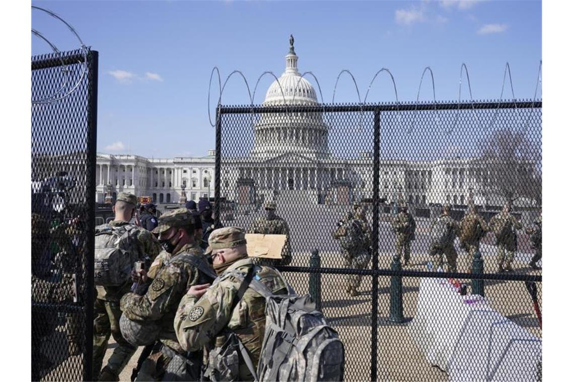 Soldaten der Nationalgarde gehen durch das Tor eines Sicherheitszauns vor dem Kapitol. Foto: Jacquelyn Martin/AP/dpa