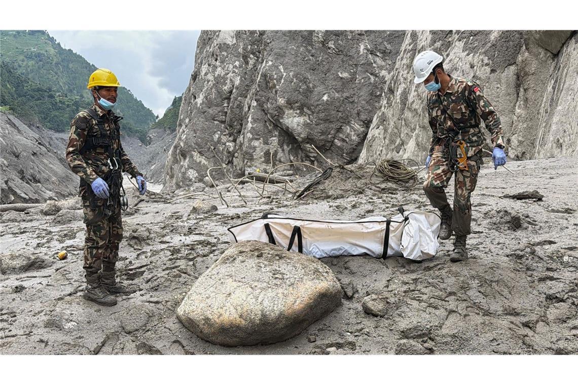 Soldaten der nepalesischen Armee tragen die Leiche eines Arbeiters, die an der Baustelle eines Wasserkraftprojekts in Upper Trishuli, Nepal, geborgen wurde. (zu dpa: «Überall Leichensäcke: Mehr als 1.000 Tote nach Himalaya-Flut»)