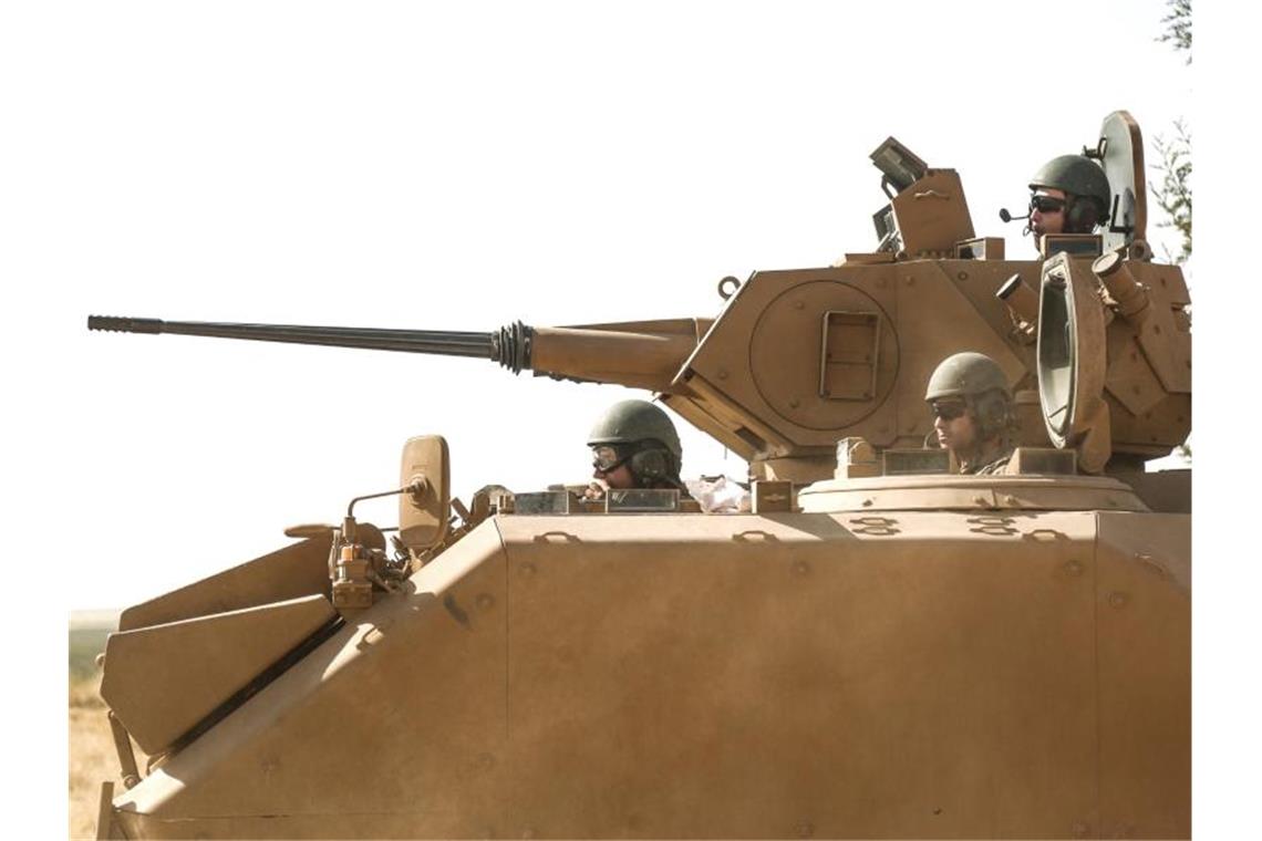 Merkel fordert Ende der türkischen Syrienoffensive Soldaten der türkischen Streitkräfte sitzen in einem Panzer nahe der Grenze zwischen Syrien und der Türkei. Foto: Anas Alkharboutli/dpa