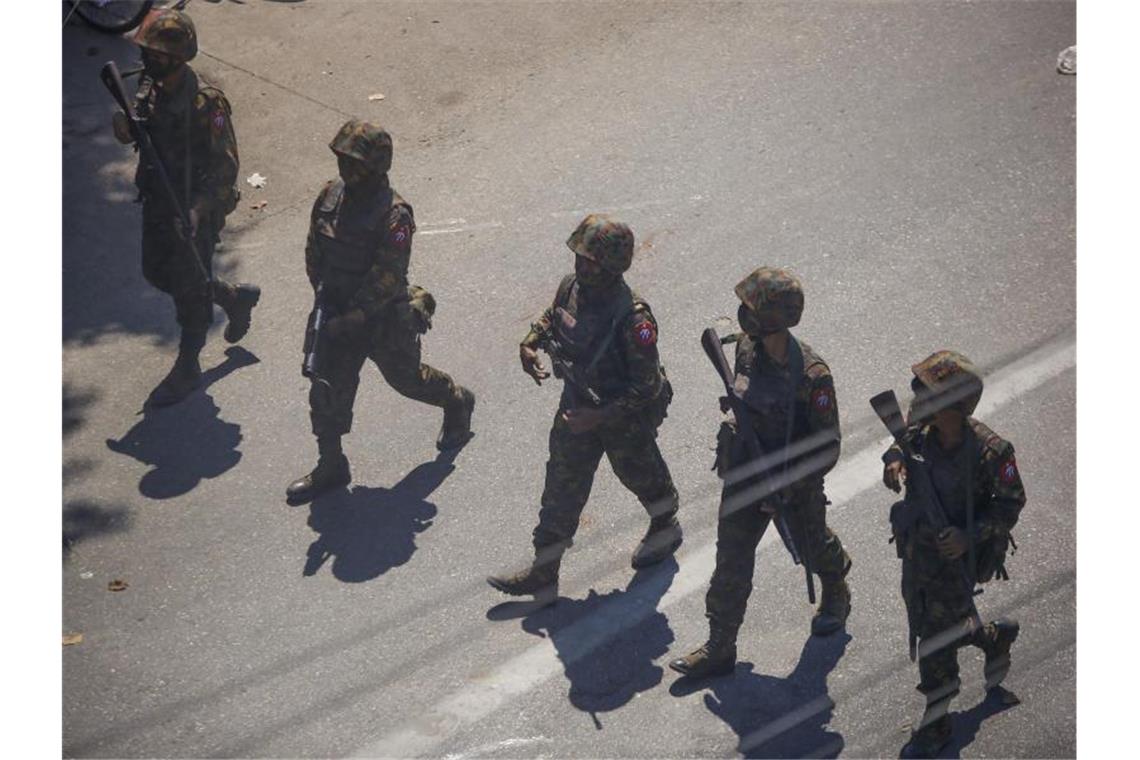 Soldaten gehen im März während eines Protestes gegen den Militärputsch in Myanmar über eine Straße. Symbolbild. Foto: Str/AP/dpa