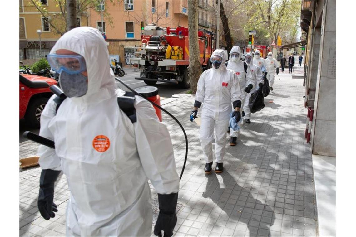 Soldaten in Schutzanzügen in Barcelona sind mit Abstand in Richtung eines Seniorenheims für Desinfektionsarbeiten unterwegs. Foto: David Zorrakino/Europa Press/dpa