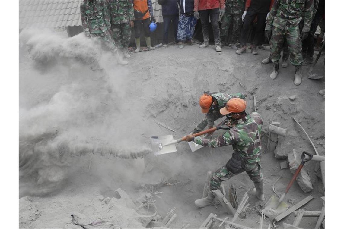 Soldaten suchen nach Opfern, nachdem ein Haus unter der Vulkanasche verschüttet wurde. Drei Tage nach dem Vulkanausbruch auf der indonesischen Insel Java ist die Zahl der Toten weiter gestiegen. Foto: Trisnadi/AP/dpa